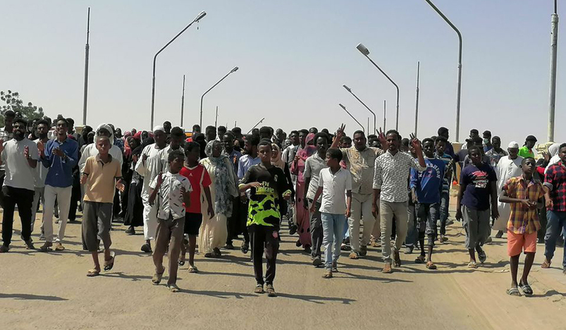 Sudanese demonstrators march and chant during a protest against the military takeover
